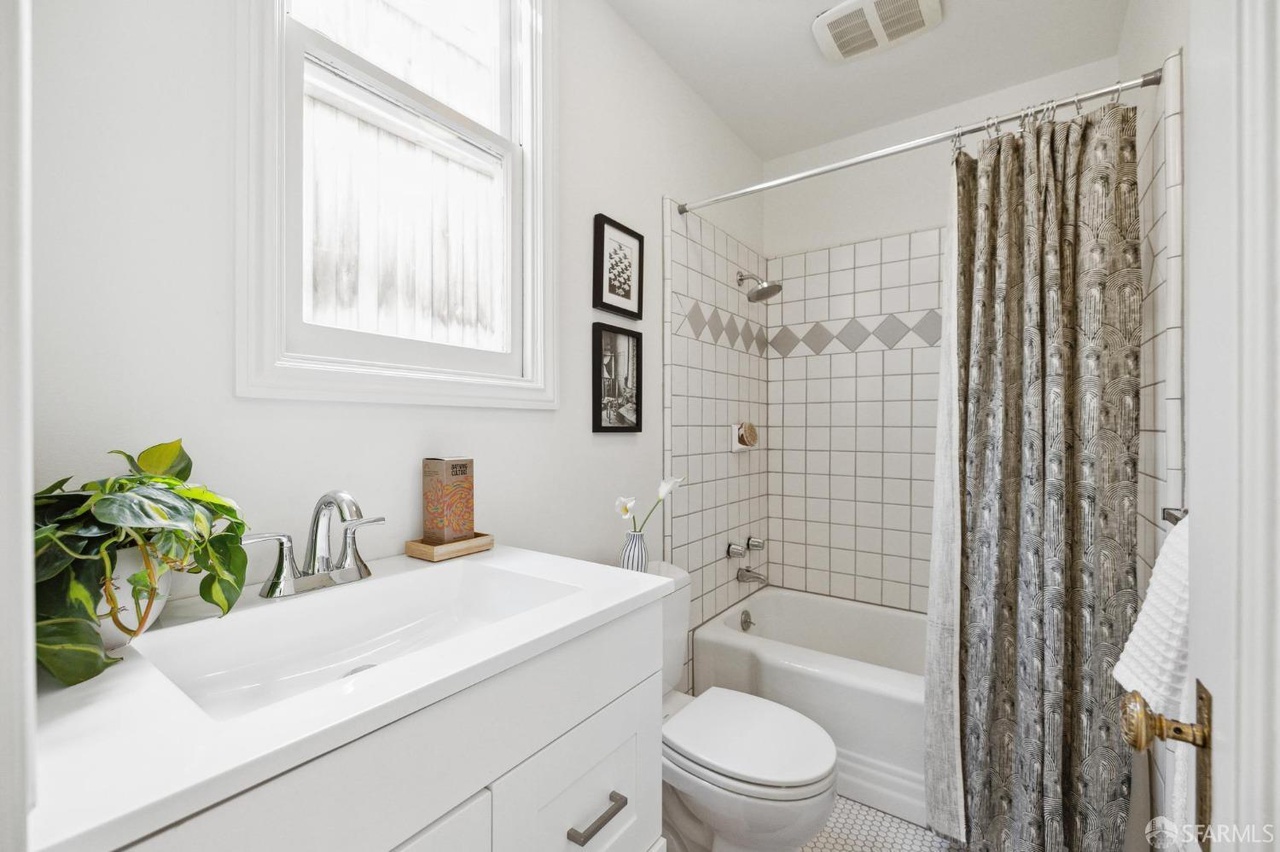 Bathroom has shower/tub combo with tile walls and floor.