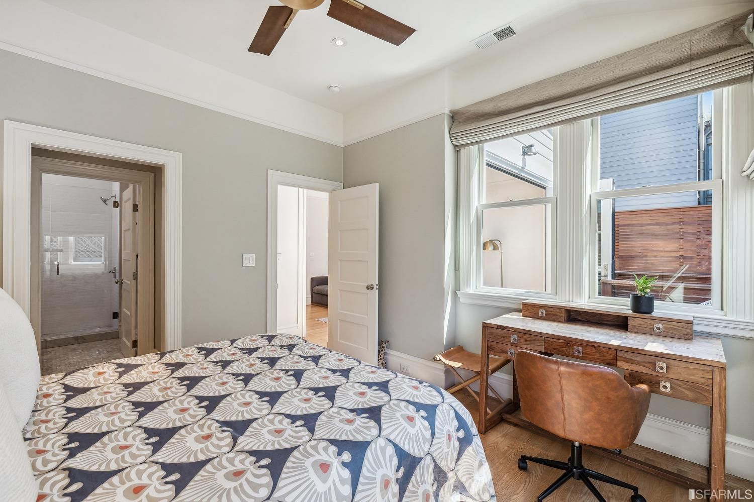 View of bedroom one, showing a desk area and plenty of natural light
