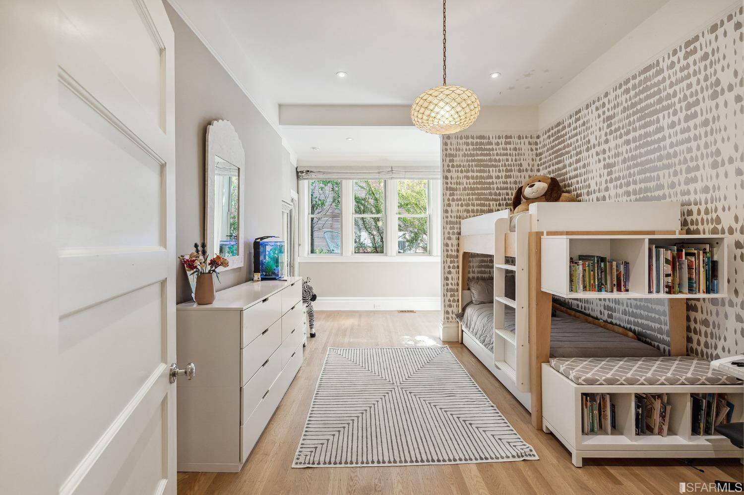 Bedroom two, featuring wood floors and three large windows at the front