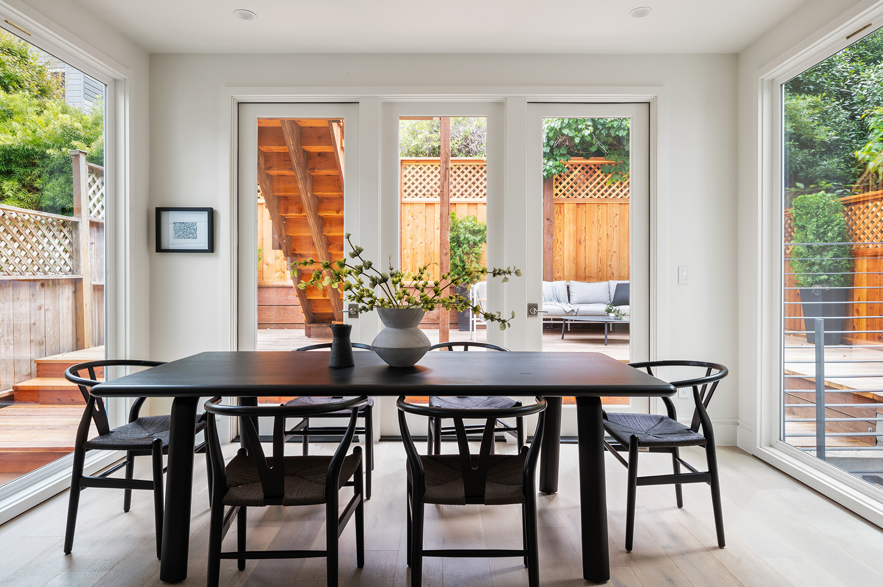 View of the dining room, showing a table surrounded by floor to ceiling windows on three sides
