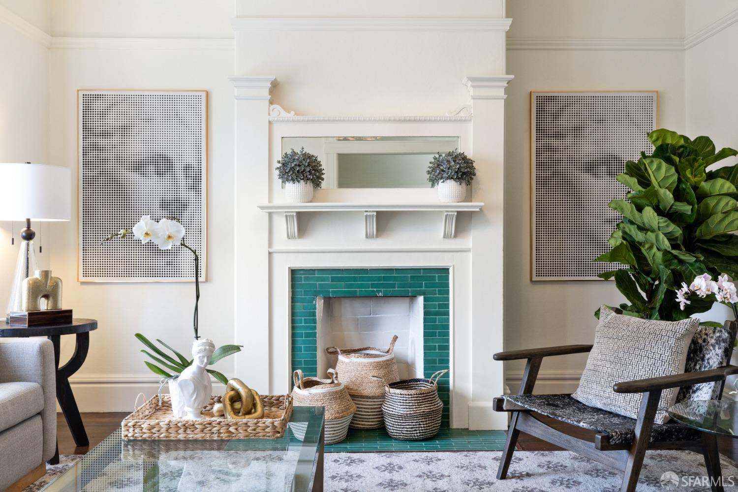 Photo with fireplace in living room is centered.  There is beautiful teal green tile detail around fireplace and large wooden mantel.