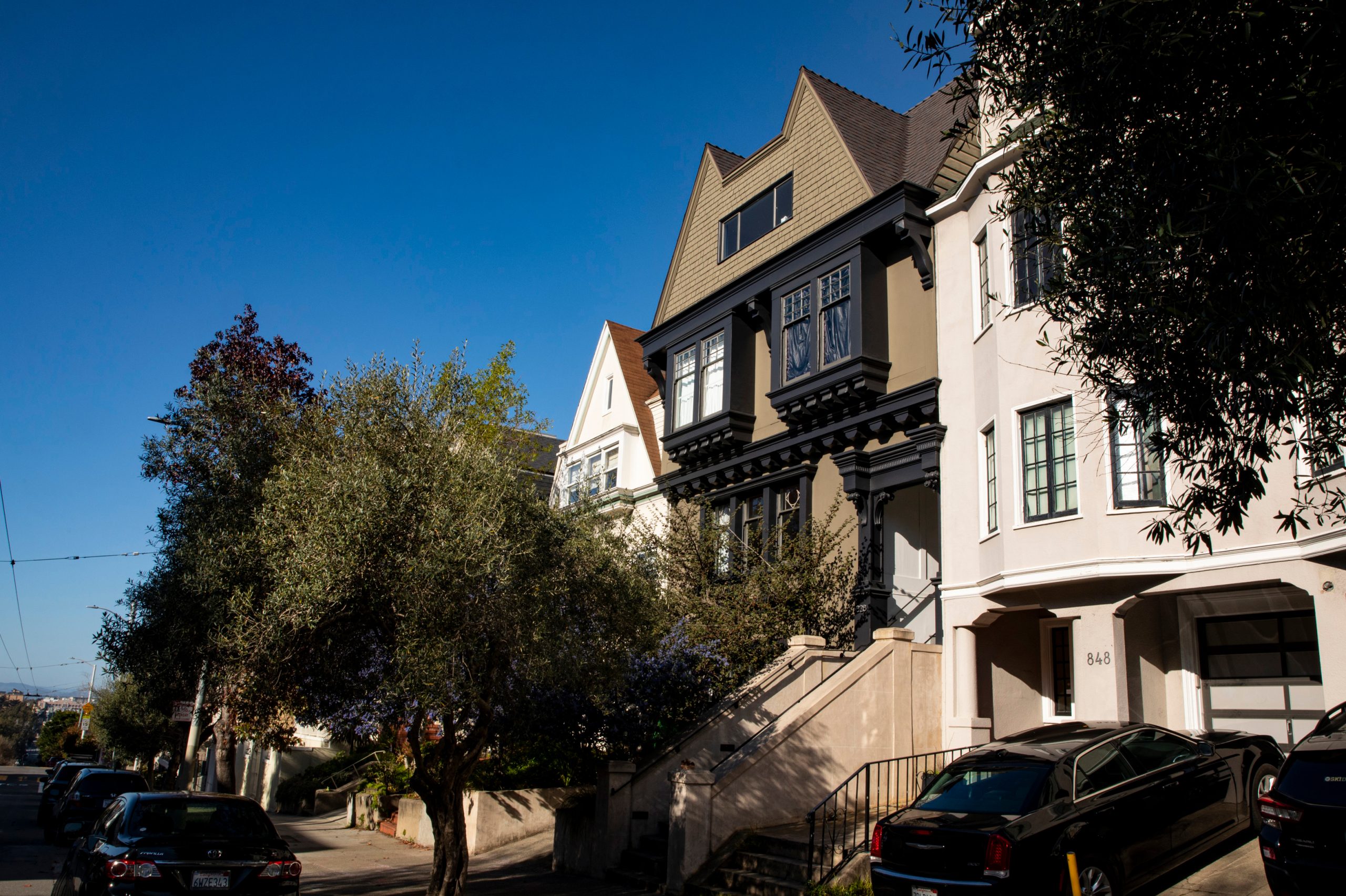 Side street view of 828 Ashbury, showing near by homes and tree-lined street