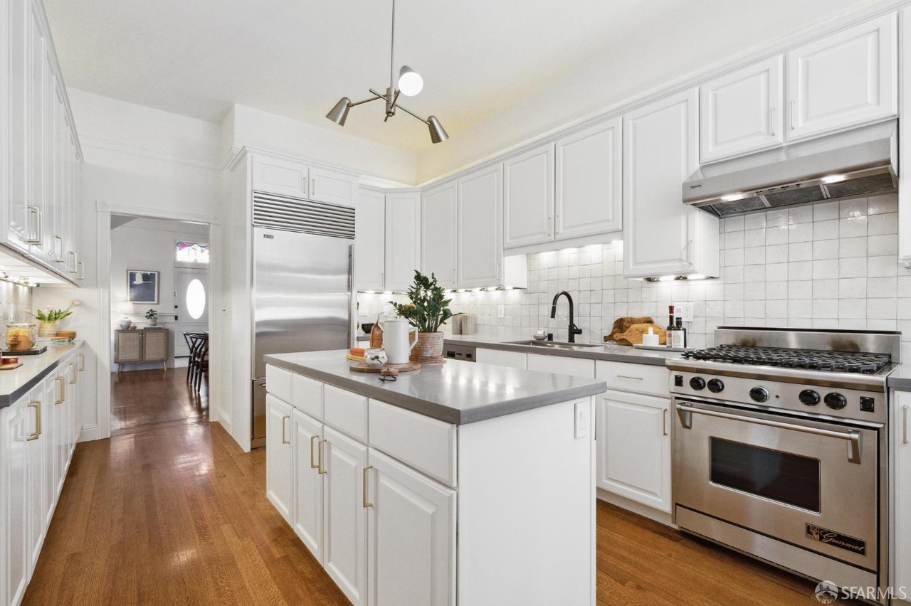 Kitchen has hardwood floors throughout and stainless steel appliances.