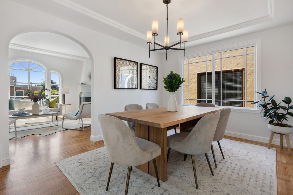 View of a formal dining room and living room, featuring wood floors