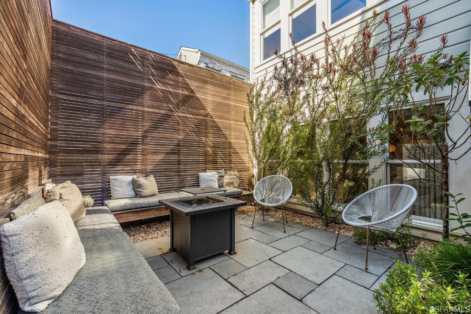 View of the lower patio with stone pavers and privacy wall