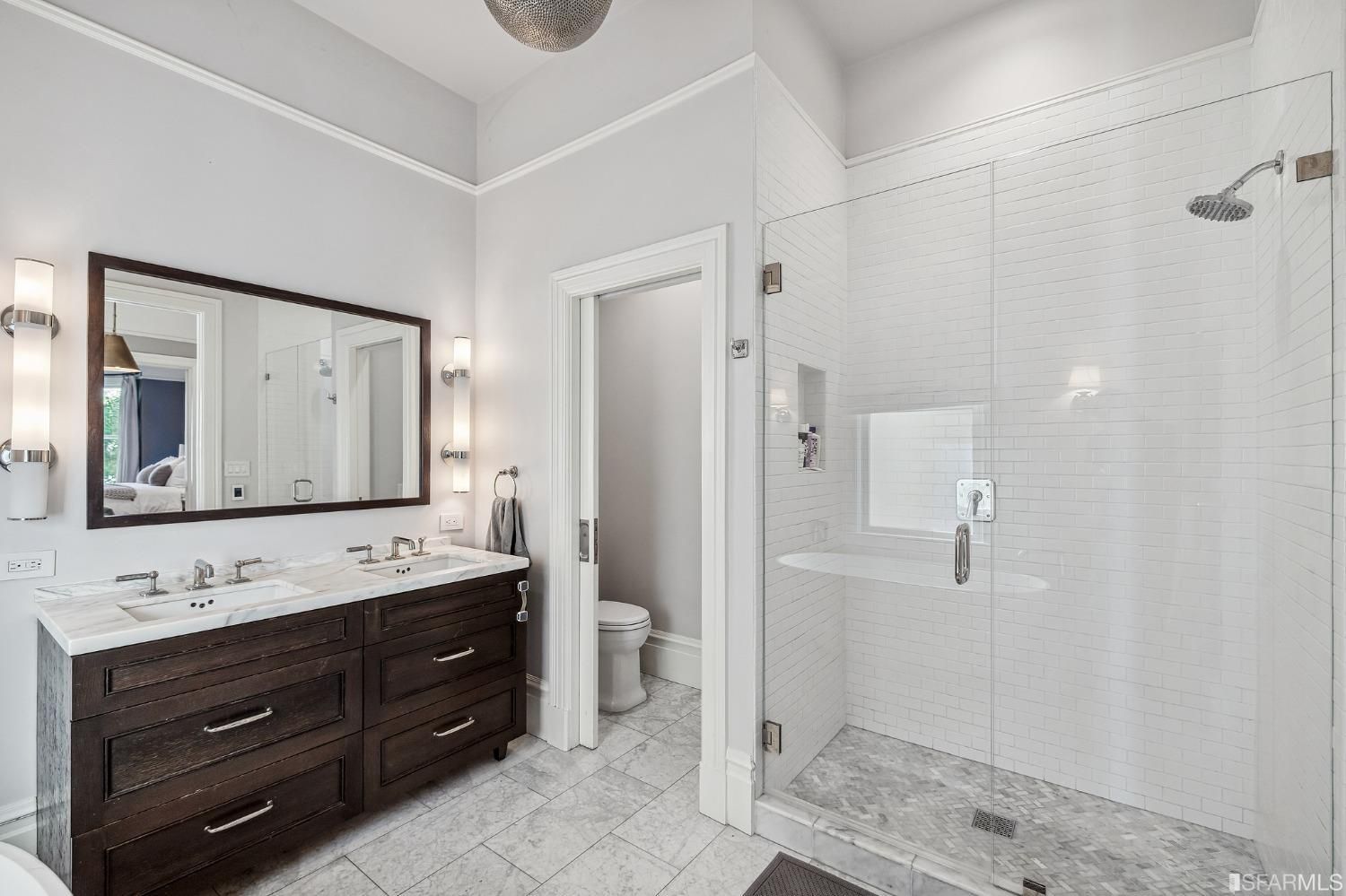 Primary ensuite bath, showing the large glass shower and modern double vanity