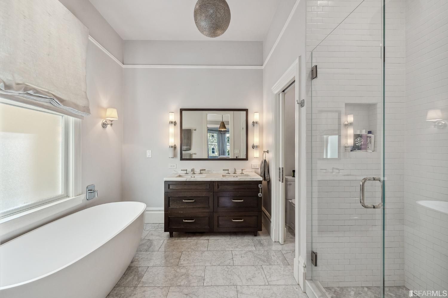 Primary ensuite, featuring a large free-standing bath tub, glass shower, and double vanity