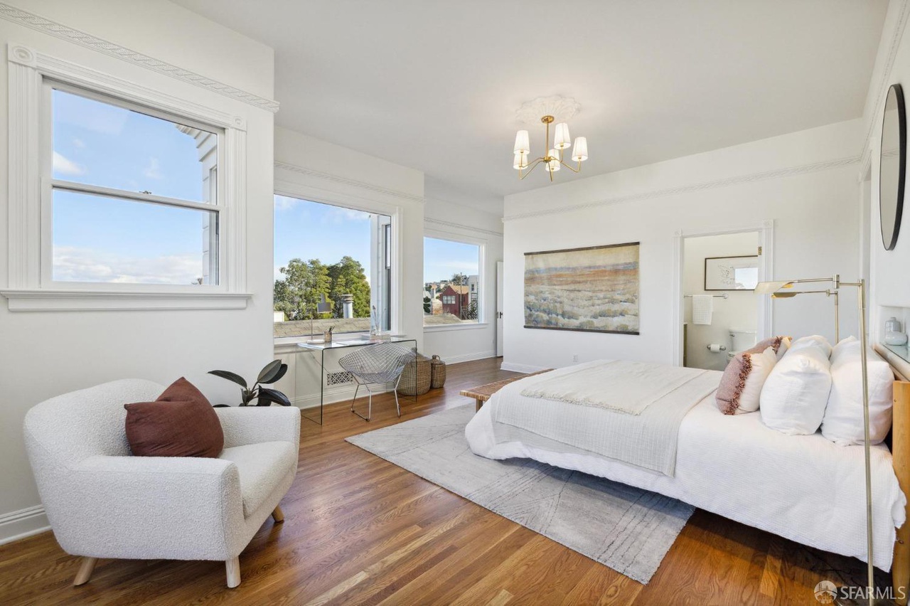 Primary has small sitting area near french doors.  Looking over bedroom you see the door to on suit bathroom.