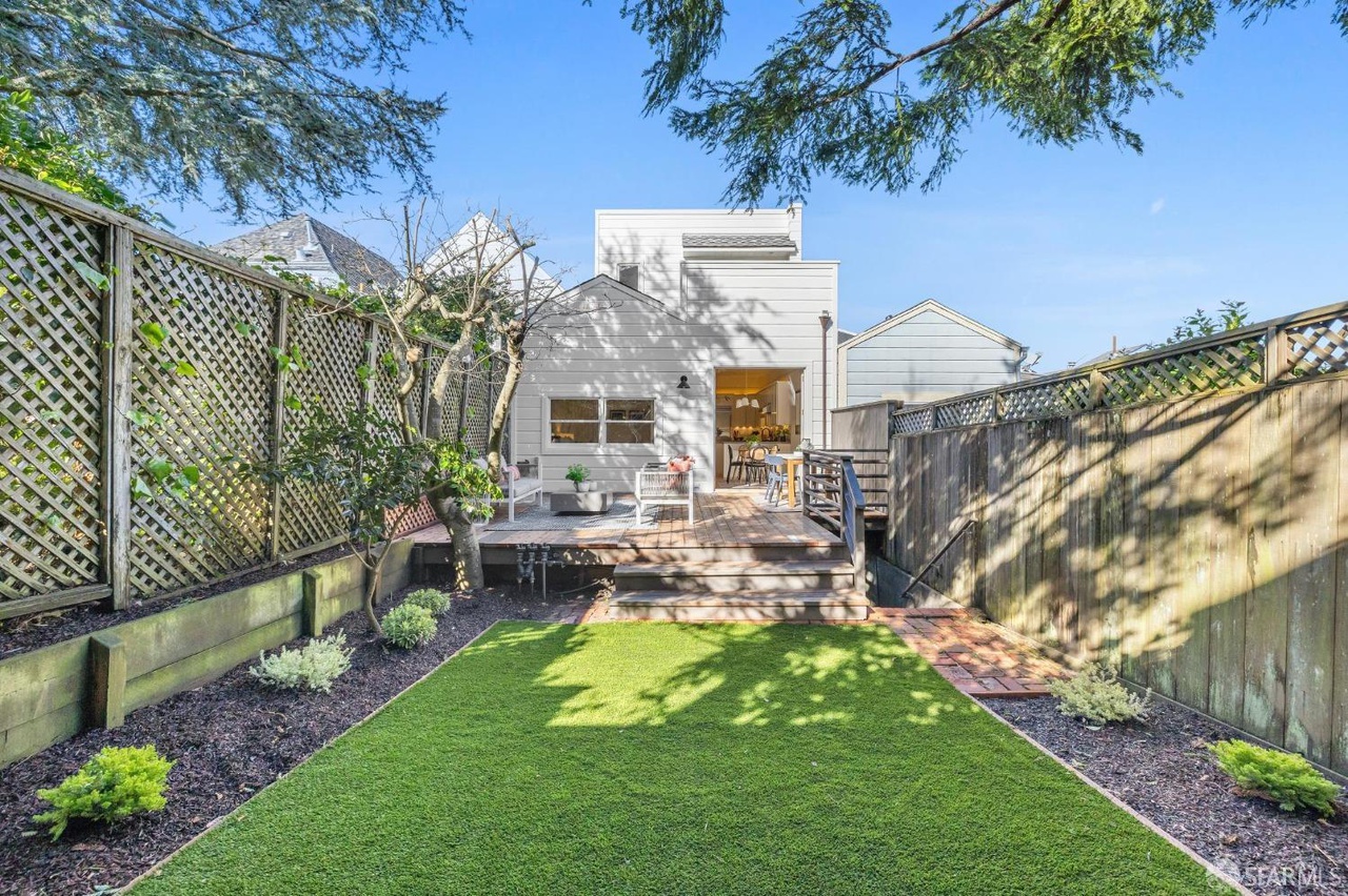 Looking back over the turf grass to rear exterior of home.