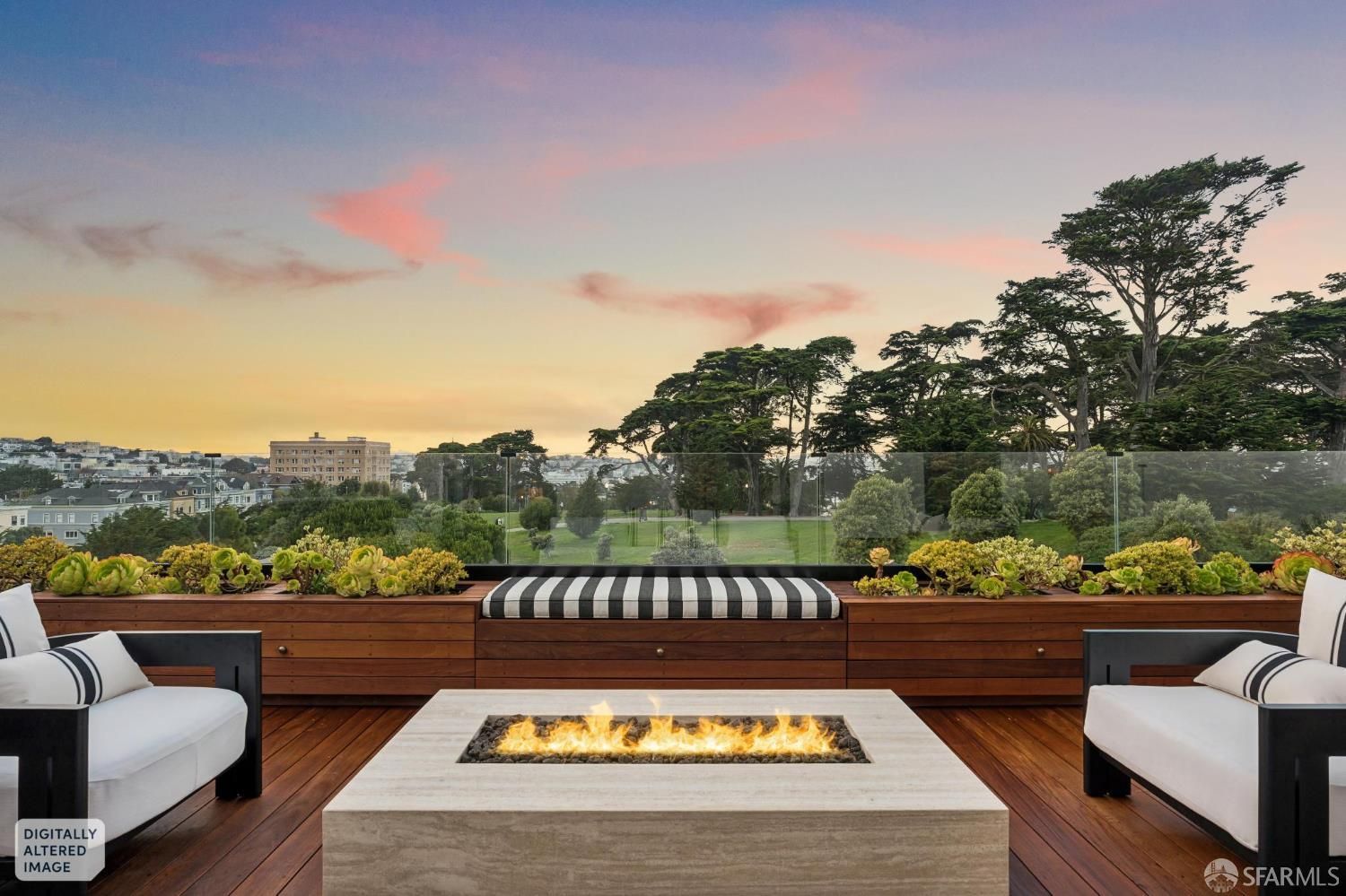 Rooftop deck with a stone fire pit, two armchairs, and a built-in bench overlooking a city park at sunset. Rooftop deck with a stone fire pit, two armchairs, and a built-in bench overlooking a city park at sunset.