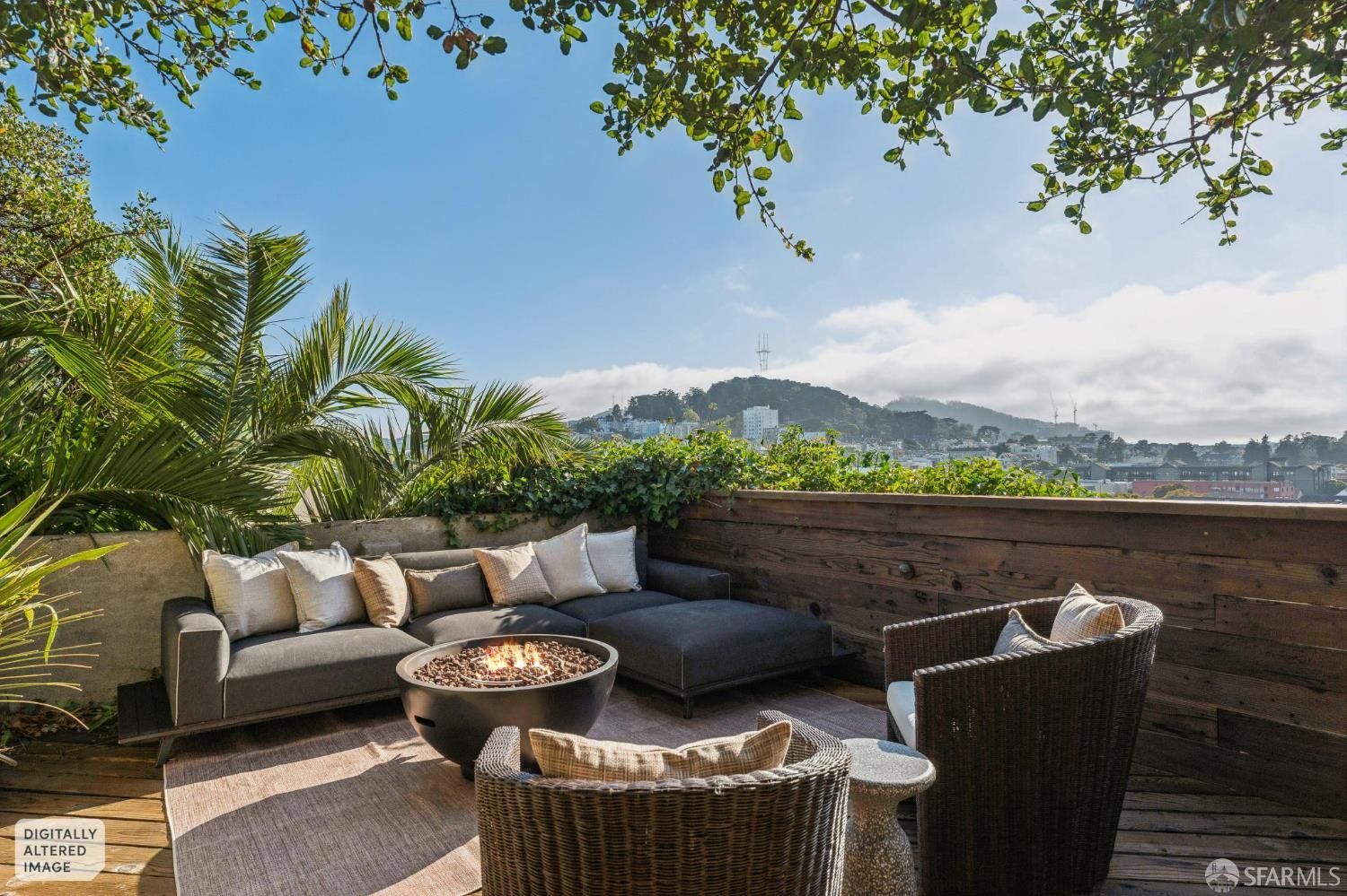 A rooftop patio with a gray sectional sofa, two wicker armchairs, and a lit fire pit overlooking a city landscape. A rooftop patio with a gray sectional sofa, two wicker armchairs, and a lit fire pit overlooking a city landscape.